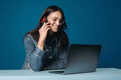 A woman handles work while talking on her smartphone on a blue background set Stock Photos