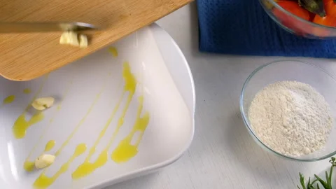 Woman hands adding garlic to baking sheet with oil to bake vegetables. Stock-Footage 312455808