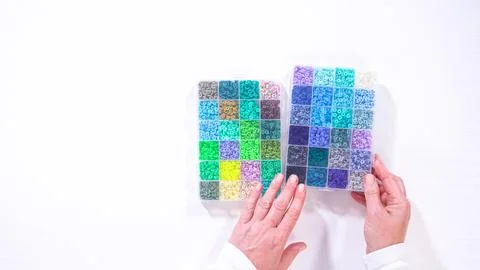 Woman Hands Amidst a Rainbow Array of Beads for Jewelry Crafting 写真素材