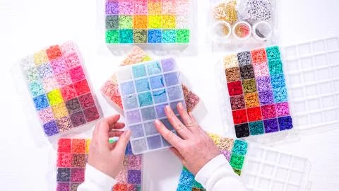 Woman Hands Amidst a Rainbow Array of Beads for Jewelry Crafting Fotos de archivo
