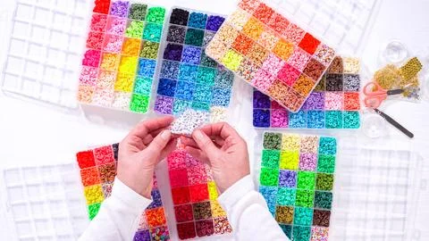Woman Hands Amidst a Rainbow Array of Beads for Jewelry Crafting Fotos de archivo