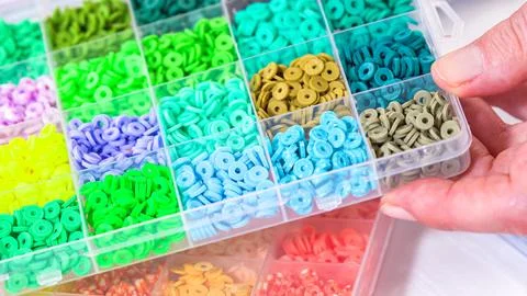 Woman Hands Amidst a Rainbow Array of Beads for Jewelry Crafting 库存照片