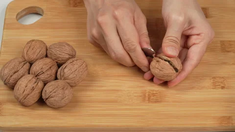 Woman Hands Cracking Walnut With Tool On Wooden Board Stock Footage 332828778