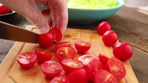 Woman hands in gloves using knife cuttting cherry tomatoes home cooking close up Stock Footage 148992407