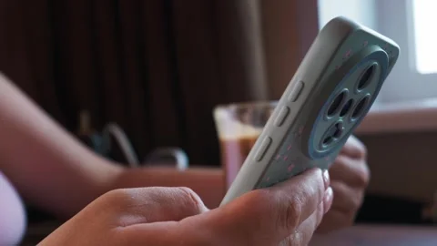 Woman Hands Holding Smartphone with Patterned Case Near Window Stock Footage 339181163