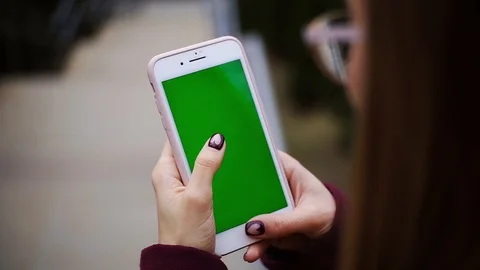 Woman hands holding using smartphone with vertical green screen on the street Stock Footage 105204053