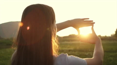 Woman hands making frame gesture with warm sunset on background mountains Stock Footage 283620739