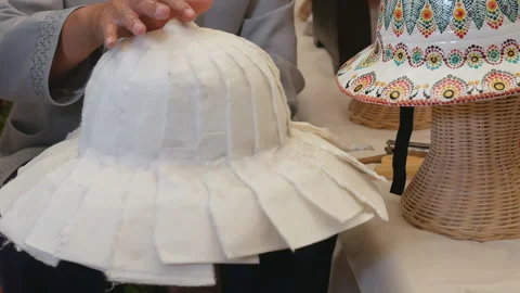 Woman hands making a pith hat or pith helmet from mulberry paper Stock Footage 345128590