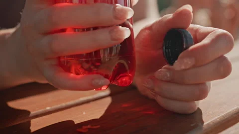 Woman hands opening red plastic bottle in bright outdoor light with cap liquid Stock Footage 345968798