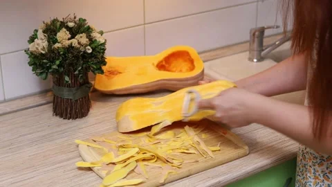 Female hands making butternut squash noodles with a vegetable peeler.Top  view Stock Photo - Alamy