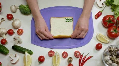 Woman hands put slice of cheese on toast on chopping board Stock Footage 229847013