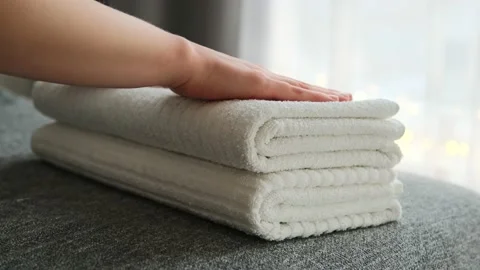 Woman hands putting stack of fresh clean white bath towels on the bed. Stock Footage 146793849