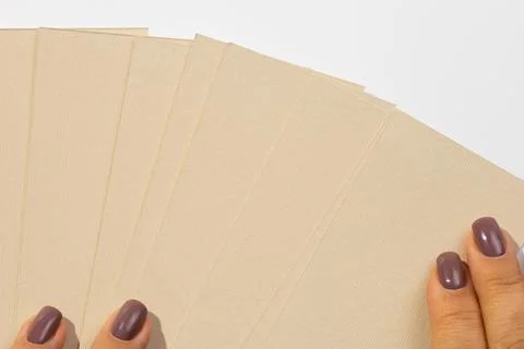 Woman hands putting stack of gray-brown cardboard rectangular blank tags for Stock Photos