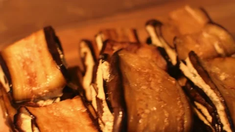 Woman hands roll eggplants with walnuts spread and put to plastic container a Vídeos de archivo 201250283