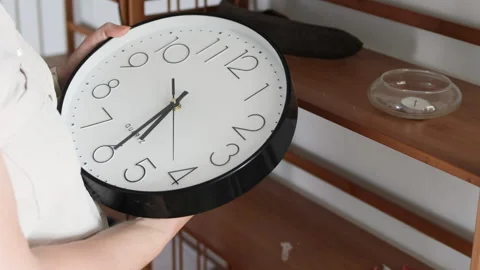 Woman hands setting time on analog black clock. Stock Footage 308537704