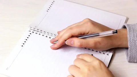 Woman hands trying to write something in the notepad on the table Stock Footage 220827441