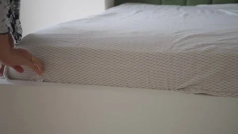 Woman hands tucking in grey patterned fitted sheet on white bed frame in br.. Stock Footage 332104912