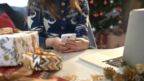 Woman hands typing on smart phone on the table with christmas decoration and Stock Footage