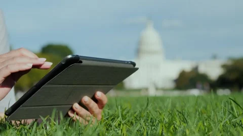 Woman hands using digital tablet computer in public park on grass near Unit.. Stock Footage 335052983