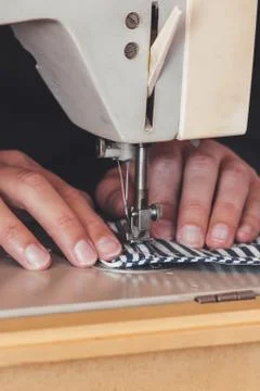 Woman hands using the sewing machine to sew a colorful face medical mask during Stock Photos