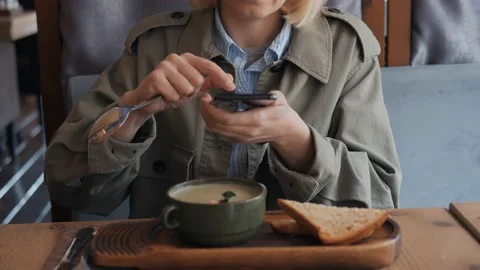 A woman hands using a smartphone camera to shoot a plate of soup in a restaurant Vídeo Stock 131370244