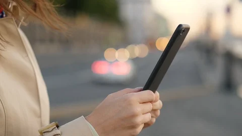 Woman hands using smartphone close up against evening road and cars headlights Stock Footage 95695769