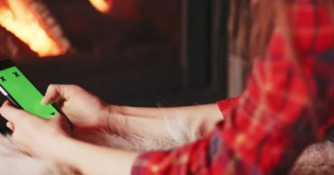 Woman Hands Using SmartPhone with Green Screen by Fireplace. 4K SLOW MOTION 库存影片 69262980