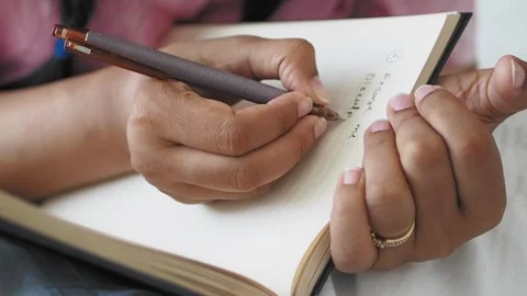 Woman hands writing notes with pen in notebook closeup shot of journaling c.. Stock Footage 332624805