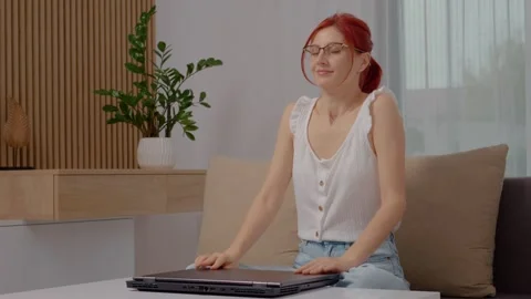 Woman happily completes a project while typing on her laptop at home Stock Footage 329231046
