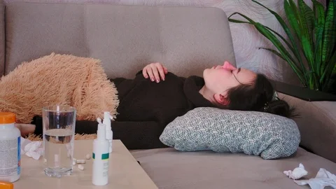 A woman has flu in the fall. She blows her nose and coughs into a handkerchief Видео 115053433