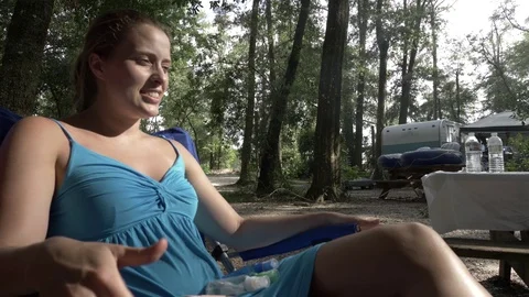 Woman Has Lively Discussion While Camping with Travel Trailer Stock Footage