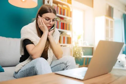 Woman has some problems while working on laptop computer and speaking Stock Photos