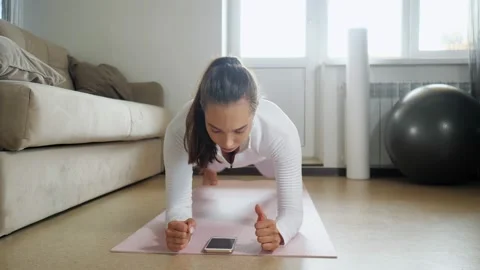 Woman has training watching tutorial on phone in room 스톡 동영상 136525164