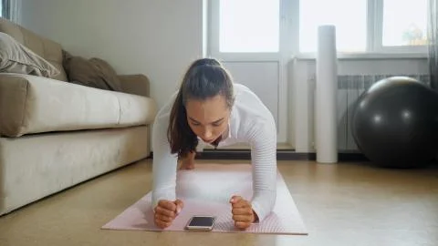 Woman has training watching tutorial on phone in room 写真素材
