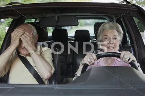 Woman has trouble driving while man in passenger seat despairs Stock Photos