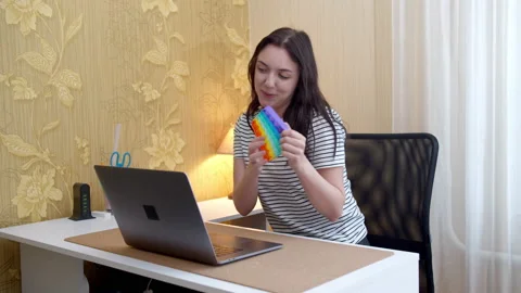 Woman has video call conversation and shows pop it toy Stock Footage 155070341