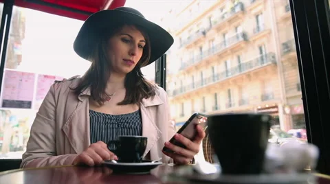 Woman in hat in cafe with smartphone Stock Footage