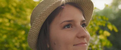 Woman with hat looking away,smiling, feeling happy and relaxed outside at sun Stock Footage 128288452