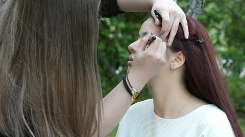Woman having applied using pencil eyeliner by makeup artist Stock Footage 68821896