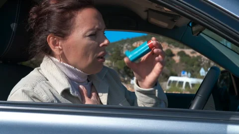Woman having asthma attack using inhaler in car. Stock Footage 330686262