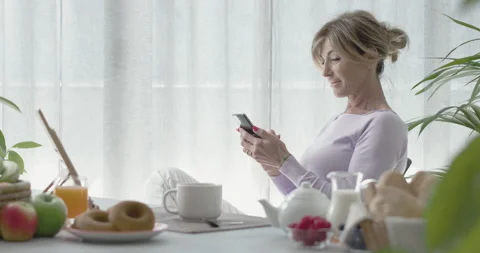 Woman having breakfast and using phone Stock Footage 297761068