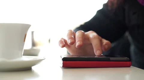Woman having coffee while using smartphone and texting Stock Footage 45771584