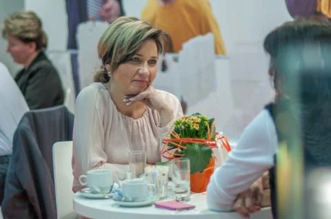 Woman having a conversation while having a coffee attending an event at the c Stock Photos