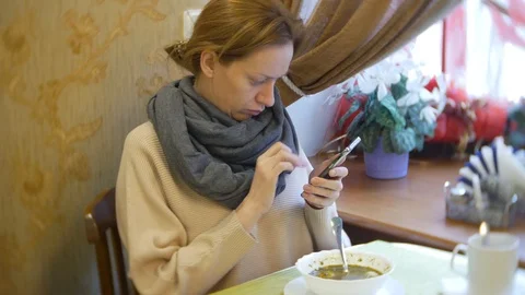 A woman is having dinner in a cafe using a smartphone Stock Footage 86255214