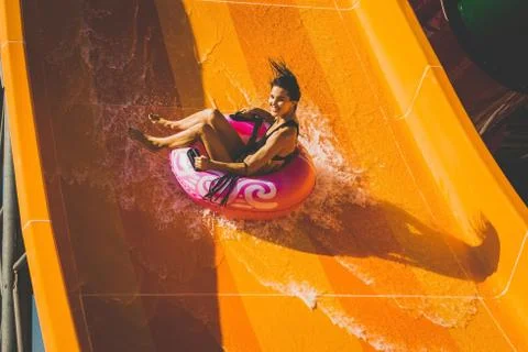 Woman having fun going down on the water slide Stock Photos