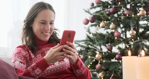 Woman having fun using mobile phone on Christmas eve Stock Footage 129423208