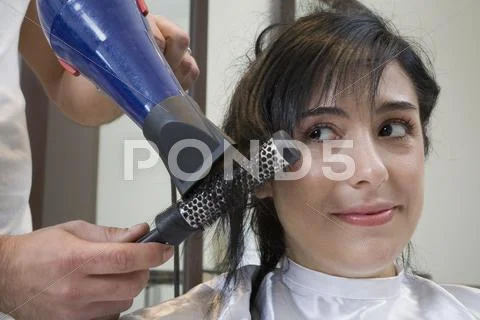 Woman having hair brushed and blown dry Stock Photos