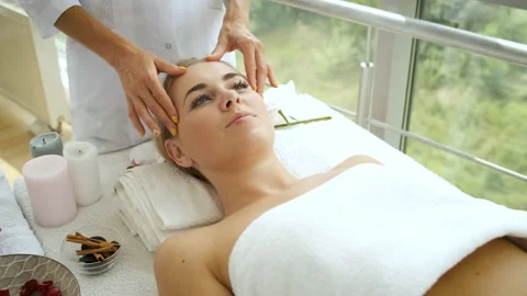 Woman is having a head massage in a modern spa with panoramic windows. Health Stock Footage 139909853