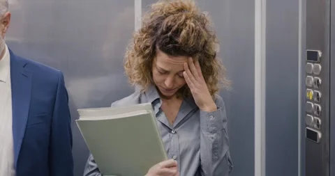 Woman having an headache in the elevator Stock Footage 306127413