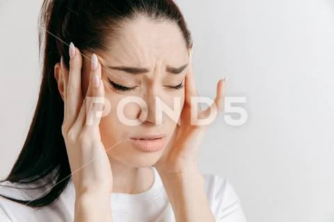 Woman having headache. Isolated over gray background. Stock Photos